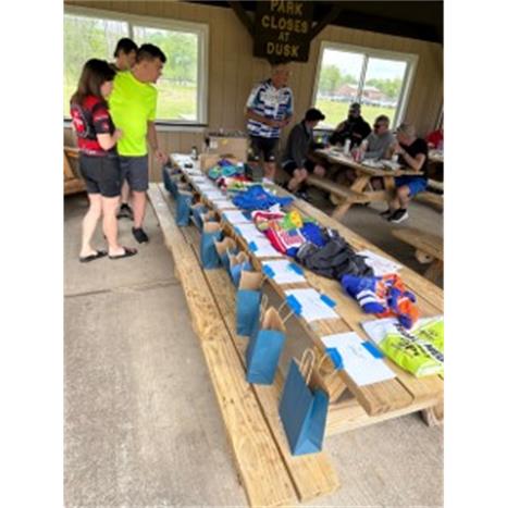 A group of people sitting at a table with bags Description automatically generated with low confidence